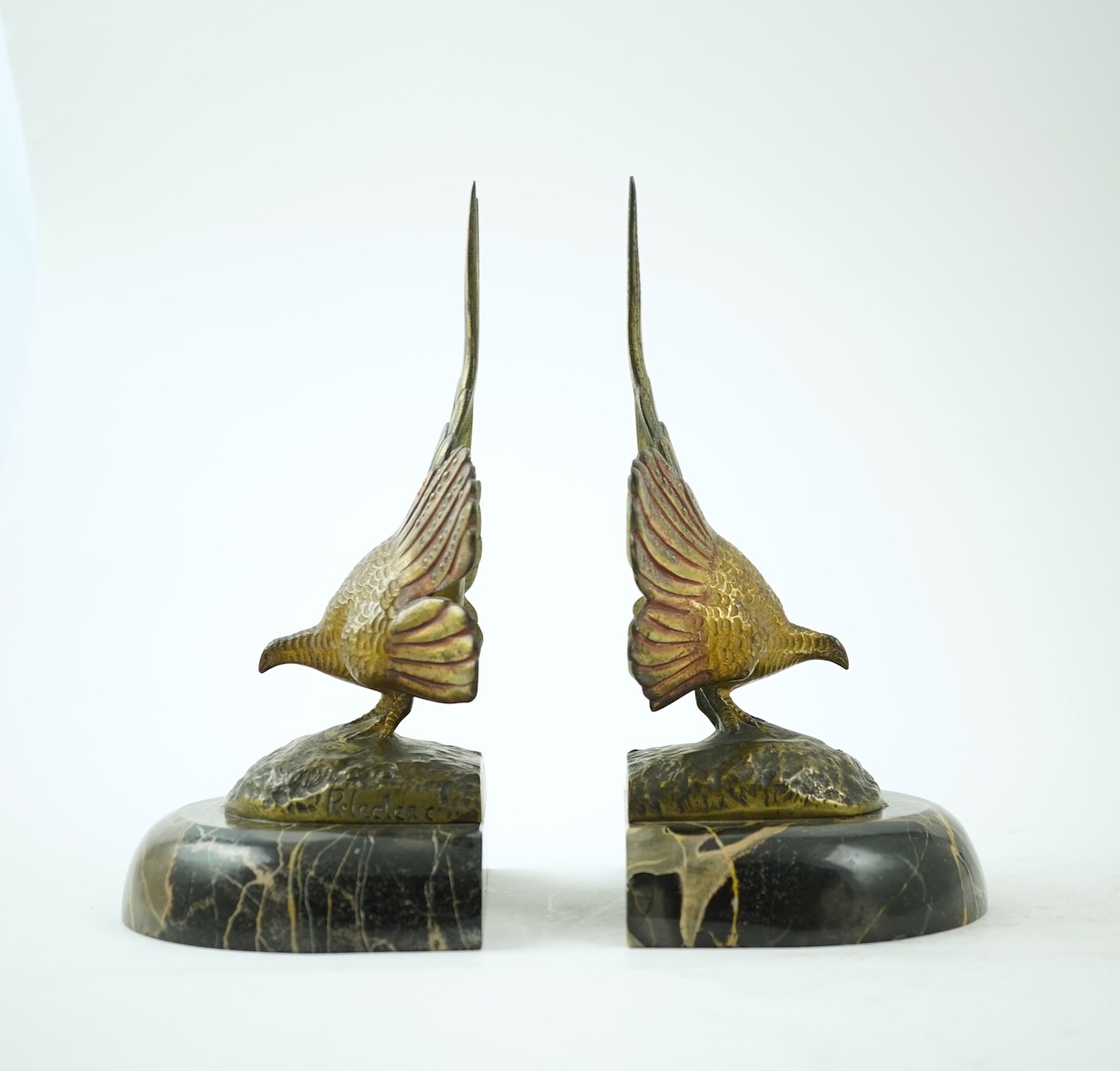 A pair of bronze peacock bookends, with remains of coloured pigments, marble plinths, signed R. Leclerc, 20cm
